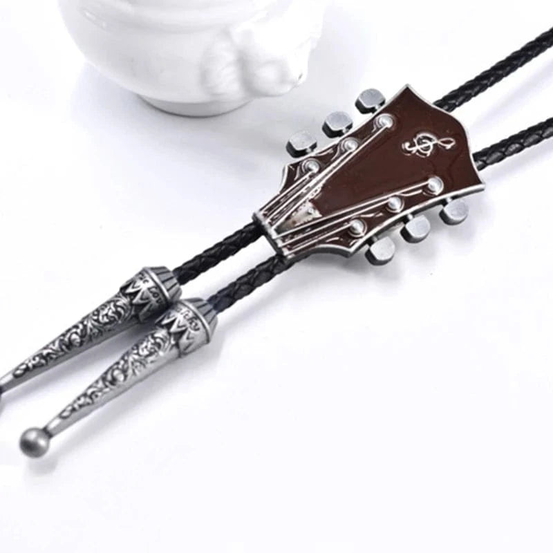 Bolo tie med gitarrhuvud i metall och läderrem